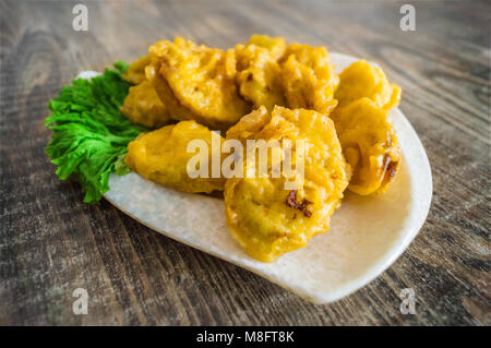 Eggplants in batter are stuffed with minced meat. The Chinese dish is deep-fried. Scene in the real conditions of the restaurant Stock Photo