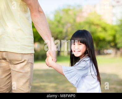 father holds the hand of little girl Stock Photo