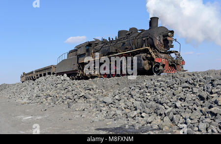 Locomotive of a spoil train at the tip in Fuxin. The coal mine system ...