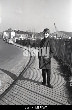 1960s, historcial, young man standing on the pavement in the fashion of the day, donkey jacket and desert type boots and with a haircut like a 'Beatle', Clayton, Mancheser, England, UK. Stock Photo
