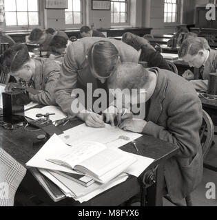 Circa late 1940s, a male teacher helping a male student with his class work at a technical college, England, UK. In post-war Britain many adults attended newly built technical colleges for the first time, on a part-time basis, as part of their apprenticeship, encouraged by the government of the day to learn new and necessary skills for the country's future. Stock Photo