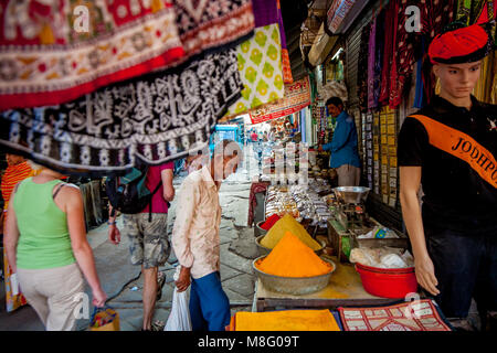 An older Indian man is standing and looking at stand with spices at busy Clock Tower market in Jodhpur India. He is considering to by some powder spic Stock Photo