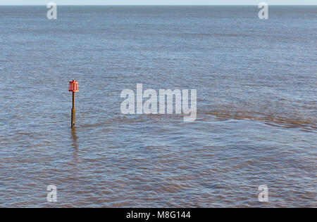 Red Groyne marker in seaCalmness Stock Photo