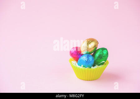 Easter Eggs Chocolates mini basket pink background. Stock Photo