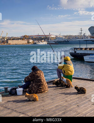 Sevastopol, Russia - November 14, 2015: Fishermen on fishing from a pier Grafskoy landing stage in Sevastopol, Crimea Stock Photo