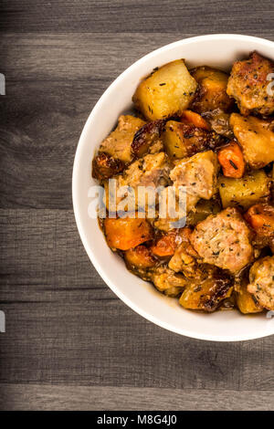 British Or English Style Slow Roasted Pulled Pork And Stuffing Casserole Against A Dark Kitchen Table Top