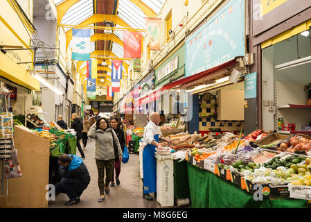 People shopping in the indoor Brixton Village Market, a multicultural community market with independent shops and ethnic restaurants in South London. Stock Photo