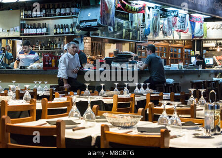 Montevideo, Uruguay - February 25th, 2018:  Customers sitting at the counter with stools at a steak restaurant inside the Port Market (Mercado del pue Stock Photo