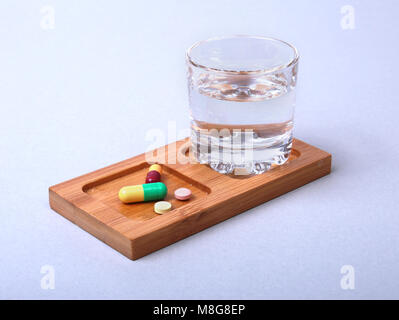 Glass of water and pills on white background Stock Photo