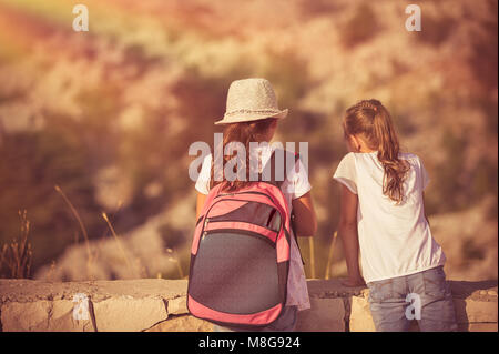 Summer camp adventures, two little girls best friends enjoying mountains hike, schoolchildren on outdoor tour, happy summer holidays in the camp Stock Photo