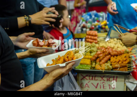 People gather around to buy street food in Ho Chi Minh City, Saigon, Vietnam Stock Photo