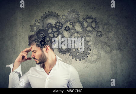 Serious young man thinking very hard solving a problem Stock Photo
