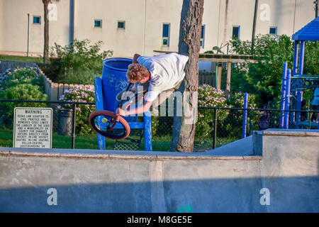 Teenage boys on their BMX bicycles practicing jumps at a skateboard park in Galveston Texas.