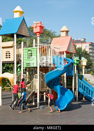 Children playing in the playground of Viharamahadevi Park (Vihara maha devi) on a sunny day with blue sky. Stock Photo