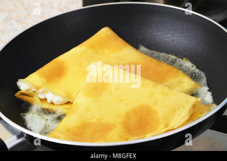Crepes with cottage cheese in frying pan, closeup Stock Photo