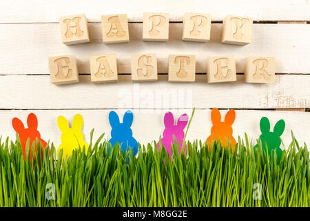 Happy Easter. Cubes with text on a white background. Fresh sprouts and Easter bunnies.  Ready postcard design for Easter. Poster. Stock Photo
