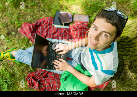 Photo from above of man with laptop on red plaid Stock Photo