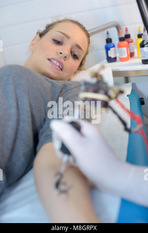 master doing tattoo on female body closeup Stock Photo