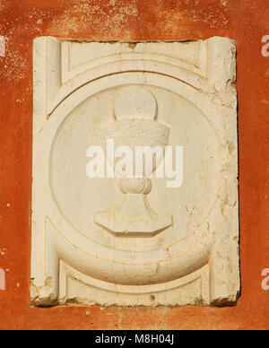 Holy Chalice with sacred host old relief on a Venice wall Stock Photo