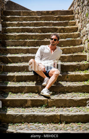 Relaxing stylish man sitting on stairs Stock Photo