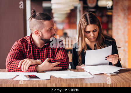 businessman and businesswoman studying documents in a cafe Stock Photo