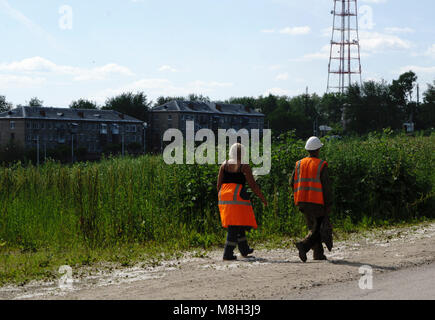 workers in orange overalls are back from lunch . Stock Photo