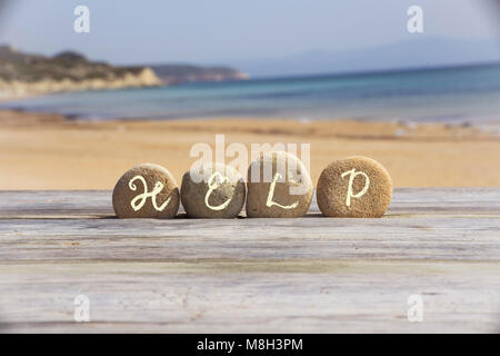 Help Sign on the beach stone. Stock Photo