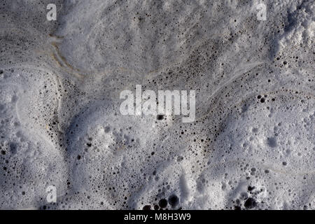white foam on water and waves background texture, gray river froth, cumulus airy sea lake foam, foam on the water with bubbles, foam aggregates, close Stock Photo