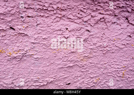 The rough texture of the decorative plaster on the wall. The surface of pink or beige with drips, drops and cracks. There are dimples and bumps Stock Photo