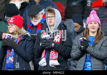 Crystal Palace fans keep warm in the stands ahead of the Premier League match at the John Smith's Stadium, Huddersfield. Stock Photo