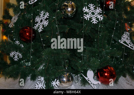The green background is pine tree. The Christmas tree decor white snowflake, gold ball, white ball and red ball. The red ball is deer pattern and snow Stock Photo