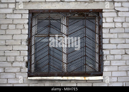 window with iron grating on stone wall Stock Photo