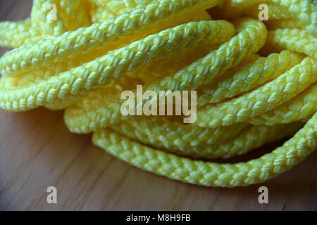 Yellow Plastic Rope on wooden Background Stock Photo