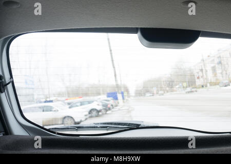 Close up of rear windshield wiper arm and blade on sun bleached blue vintage motor vehicle . Stock Photo