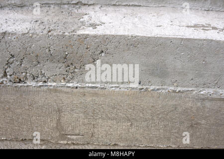 Worker spreading fresh concrete pouring from mixer's discharge chute Stock Photo