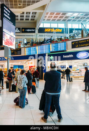 London Gatwick, March 15th, 2018: Passengers check their flight information on a digital display at London Gatwick's North Terminal Stock Photo