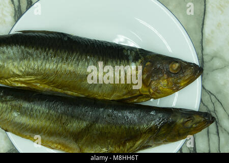 Hot smoked herring on plate isolated on a white background Stock Photo