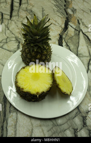 Pineapple slices and pineapple shelled Asian-style on the old wooden background. Tropical fruit concept Stock Photo