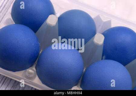Pastel colored blue and grey Easter eggs in handmade ceramic dish, bowls and kitchen towel on rustic grey wooden background. Top view point Stock Photo