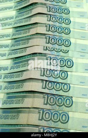 Savings, close up of male hand stacking golden coins over sky background Stock Photo