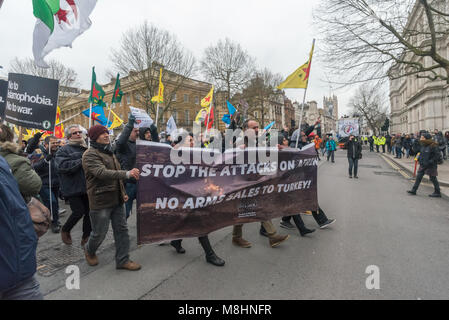London, UK. 17th March 2018. Kurds from Daymer walk across Whitehall after a police officer removes the white tape along the side of the march to protest at the gates of Downing St against the attacks on Afrin at the end of the march through London against Racism on UN Anti Racism Day. The march hosted by Stand Up to Racism began with speeches outside the BBC on Portland Place and ended with a rally in Whitehall, where angry Kurds protested calling for the government to take action against Turkey to stop its invasion of Afrin. Thousands marched despite apocalyptic weather forecasts and an ambe Stock Photo