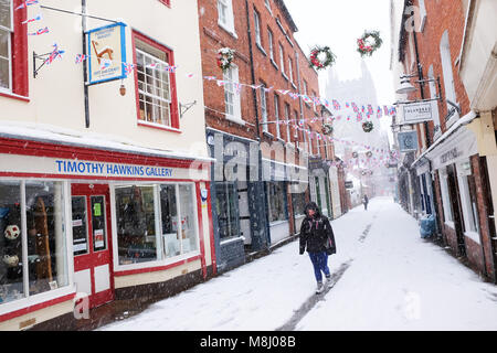 Hereford, Herefordshire, UK - March 2018 - Hereford heavy snowfall overnight continues during Sunday morning  - a pedestrian struggles along the snow covered Church Street with the Cathedral in the background - Steven May /Alamy Live News Stock Photo