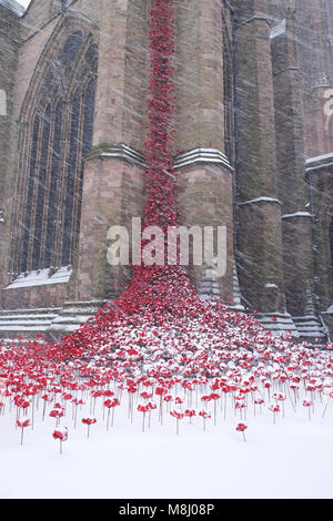 Hereford, Herefordshire, UK - Sunday 18th March 2018 - Hereford Cathedral heavy snowfall overnight continues during Sunday morning  - snow falls on the Weeping Windows ceramic poppy art installation by artist Paul Cummins that commemorates the centenary of WW1 - Steven May /Alamy Live News