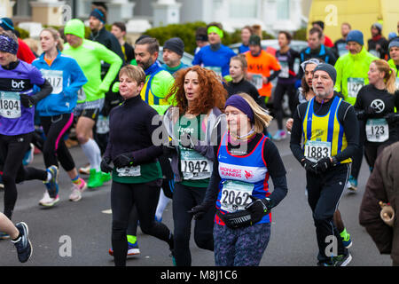 Hastings, East Sussex, UK. 18th Mar, 2018. Bitterly cold with a wind chill factor of -7°C and overcast this morning won't spoil the fun for these marathon runners raising money for charity. Organised by the Hastings Lions Club the event has been going on since 1985. Just over 3000 participants have registered to run. This half marathon is seen by some as a warm up event for the London marathon in April. Photo Credit: Paul Lawrenson / Alamy Live News Stock Photo
