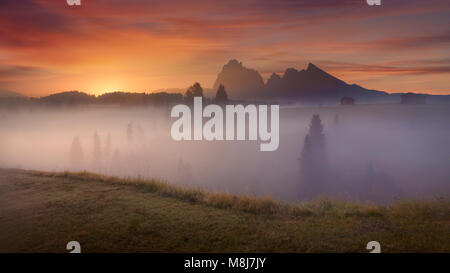 Misty landscape view in Alpe di Siusi or Seiser Alm at beautiful dawn. Long exposure photo - Dolomites mountain range, Italy. Stock Photo