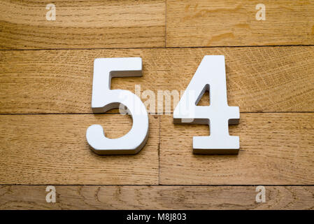 Figures fifty-four on a wooden, parquet floor as a background. Stock Photo