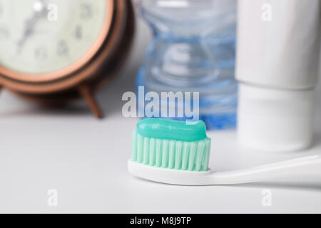 Green toothpaste on a toothbrush on white background - closeup Stock Photo