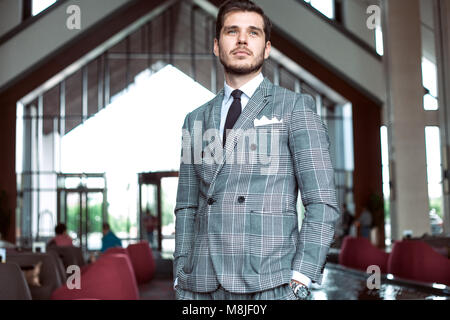 Smartly dressed businessman, smiling in modern office Stock Photo