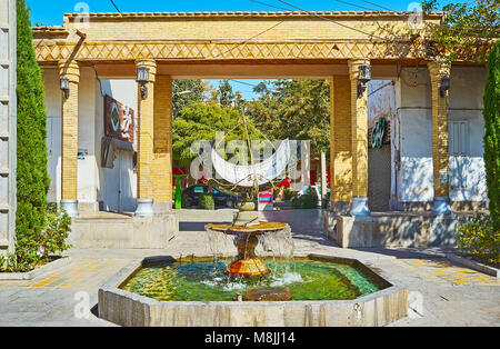 ISFAHAN, IRAN - OCTOBER 20,2017: The beautiful fountain with sundial in Julfa square of Armenian neighborhood, the decorative brick gates are seen on  Stock Photo