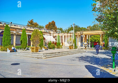 ISFAHAN, IRAN - OCTOBER 20,2017: The tiny park with thuja trees in Julfa square of Armenian neighborhood, this area is surrounded by stores and cafes, Stock Photo